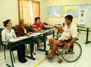 Photograph of a man in a wheelchair at a voting center in Brazil