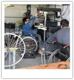 Photograph of two workers in wheelchairs working at a wheelchair construction project in Tblisi, Georgia